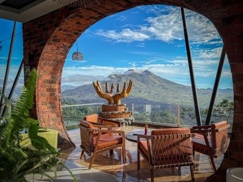 Caldera Hotel & Restaurant في Kintamani: غرفة بها طاولة وكراسي وإطلالة على جبل