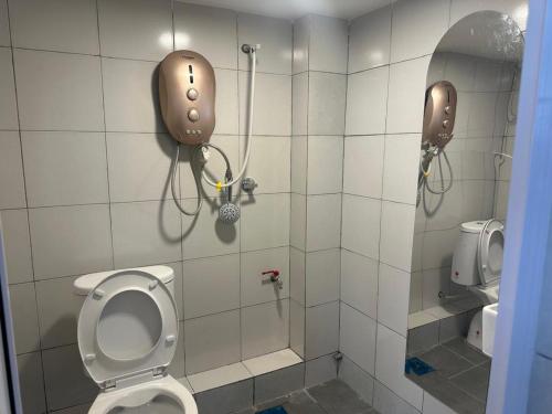 a bathroom with a shower with a toilet and a phone at Guest Room Star Avenue in Shah Alam