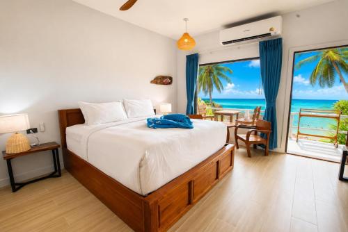 a bedroom with a bed with a view of the ocean at Crystal Bay Beach Resort in Lamai