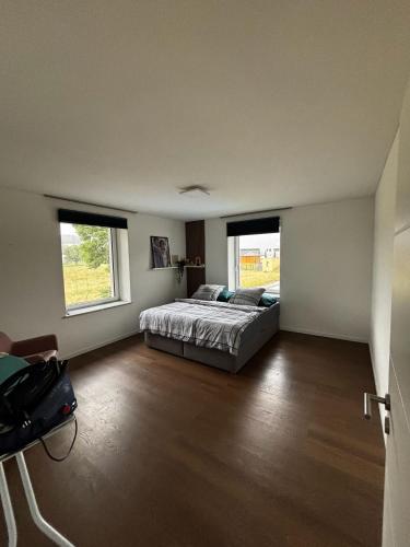 a bedroom with a bed and two windows at Casa Stein am Rhein inkl Pool in Stein am Rhein