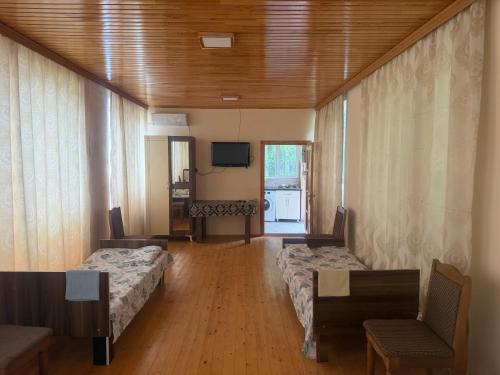 a hotel room with two beds and a television at Cozy house in Sheki