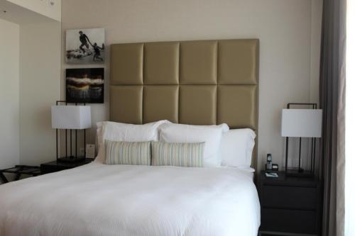 a bedroom with a large white bed with two lamps at First Class Marina Herzlia in Herzliya