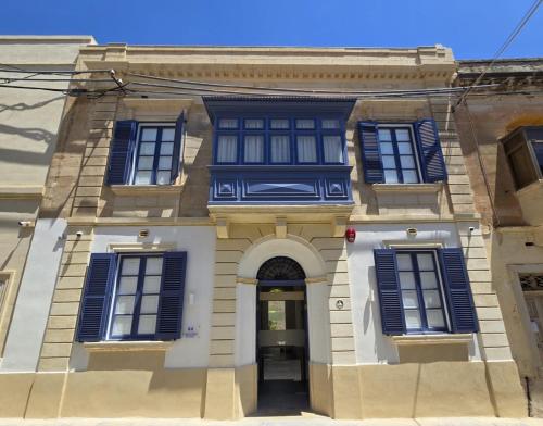 a building with blue shuttered windows and a door at Casa Lina Suites in Sliema