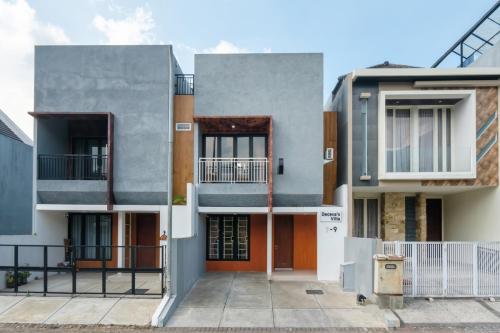 an exterior view of a building with orange doors at Calma Villa Panorama, Batu Malang in Batu