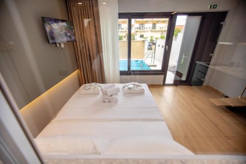 a room with a bed with towels on it at iMa-Ge Luxury in Nea Vrasna