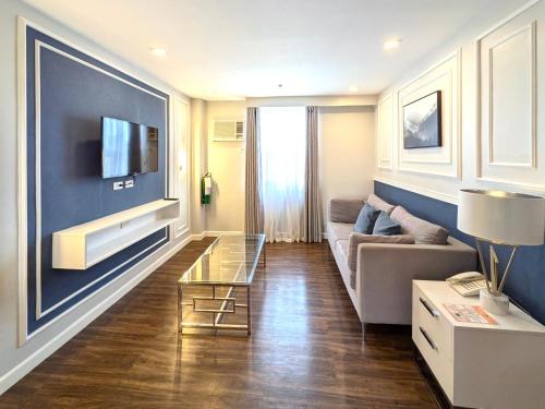 a living room with a couch and a tv at Kokotel Cebu Capitol in Cebu City