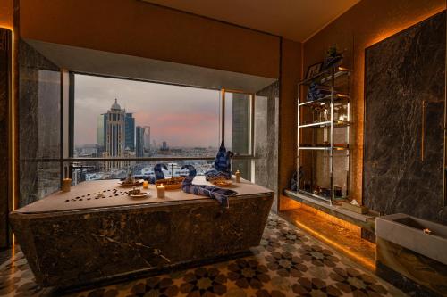 a bathroom with a tub with a view of the city at Narcissus The Royal Hotel in Riyadh