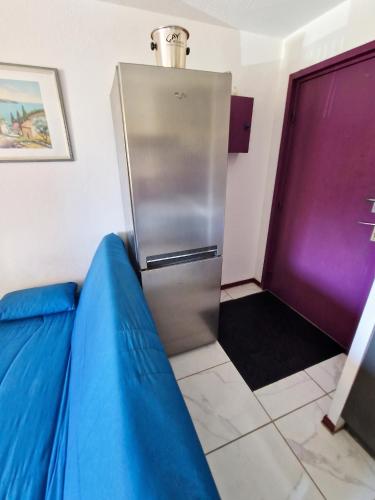 a stainless steel refrigerator in a room with purple at Appartement cosy à Gruissan, piscine partagée, 25 m² in Gruissan