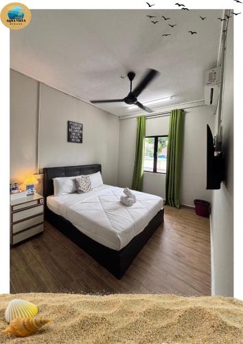 a bedroom with a bed and a ceiling fan at Aqua Vista Merang in Kampung Merang