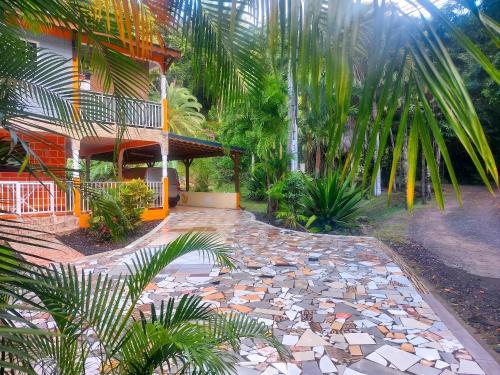 a house with a stone walkway next to a building at Maison charmante à Pointe Noire, vue montagne, jardin privé in Pointe-Noire