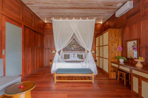 a bedroom with a bed with a canopy at Aranya Ubud Villa in Ubud