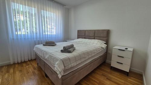 a bedroom with a bed with two towels on it at MyPlace apartmani 8 in Tuzla