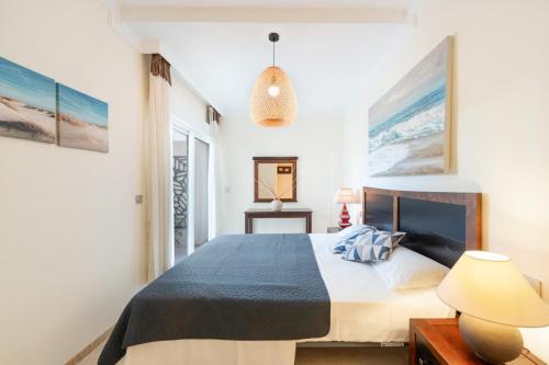 a bedroom with a bed and a pendant light at San Roque Golf Apartment in San Roque