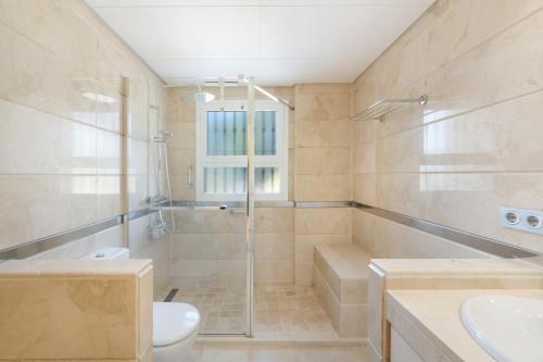 a bathroom with a shower and a toilet and a sink at San Roque Golf Apartment in San Roque