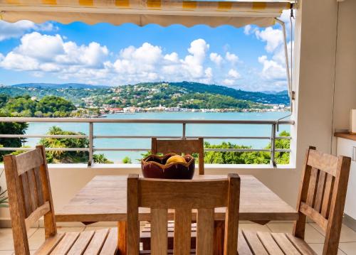 a dining room table with a view of the water at Studio charmant à La Trinité - Vue mer - 40 m² in La Trinité