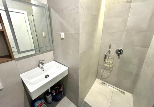 a bathroom with a sink and a shower with a mirror at 1bd New and Modern Apt with Sea View "Blue Horizon" in Bar