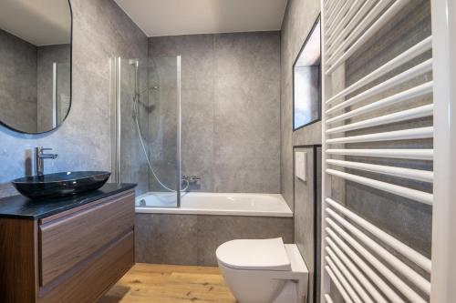 a bathroom with a sink and a toilet and a tub at Beautiful and spacious renovated home for 10 in Ostend