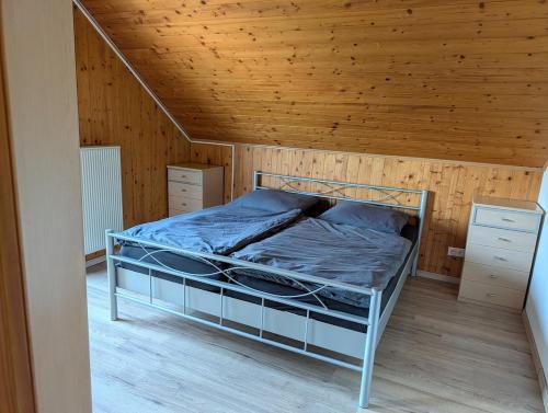 ein Bett in einem Zimmer mit Holzdecke in der Unterkunft Gemütlich & einladend in Laufenselden