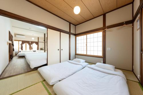 a room with three beds and a mirror at Kamenoya, 羽田空港&ディズニー直通バス,2トイレ,亀有駅徒歩7分 in Tokyo