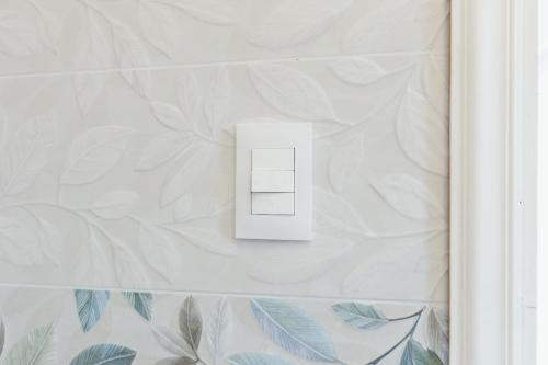 a white light switch on a white wall at Casamicciola Rooms in Casamicciola Terme