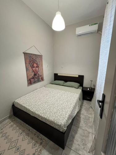 a bedroom with a bed and a painting on the wall at Home Sweet Home AXD in Alexandroupoli