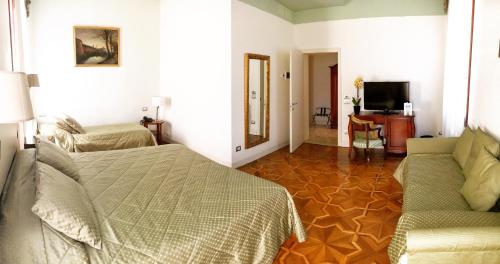 a bedroom with a bed and a couch and a television at Hotel Sant'Antonin in Venice