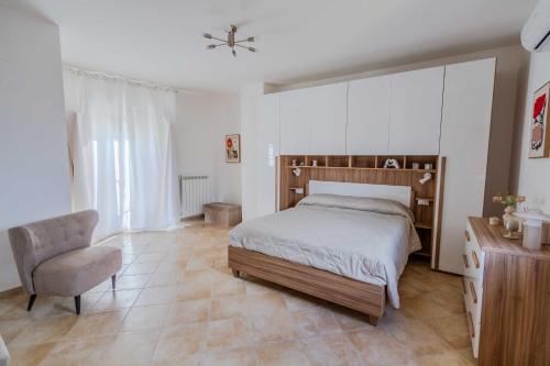 a bedroom with a bed and a chair at La Ruetta in LʼAquila