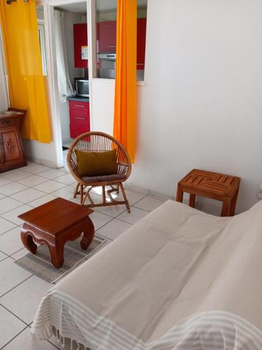 a bedroom with a bed and a chair and a table at L'îlot vacances in Saint-Pierre
