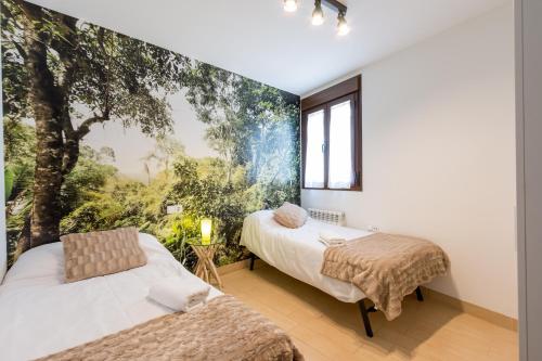 two beds in a room with a large window at Albaicin Luxury Apartments in Granada
