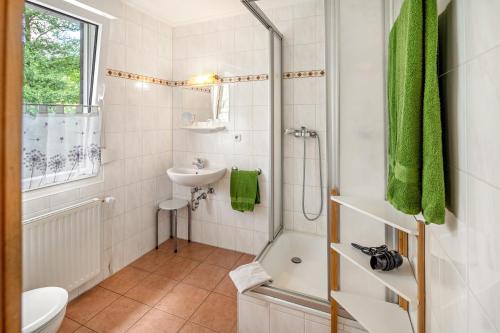 a bathroom with a shower toilet and a sink at Haus Hermes in Kirchhundem