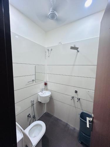 a white bathroom with a toilet and a sink at hotel capetown in Sirsa