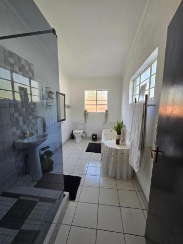 a bathroom with a shower and a sink and a toilet at The Calm Views Holiday Home in Hazyview