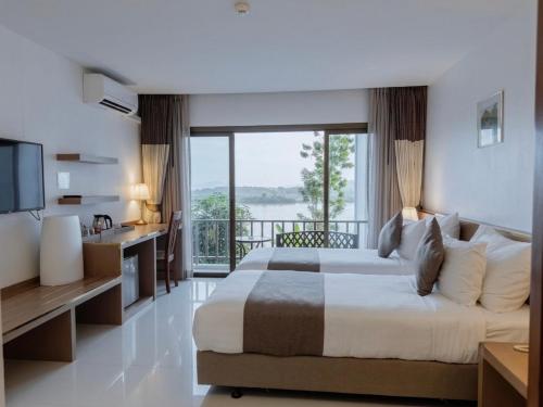 a bedroom with a large bed and a balcony at Siam Triangle Hotel Chiang Sean in Chiang Saen