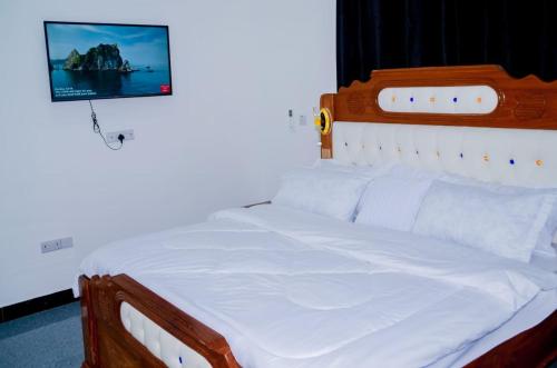 a bedroom with a white bed with a picture on the wall at Ray Infinity Suites in Paje