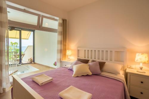 una camera da letto con un letto grande e una grande finestra di Hedera Estate, Villa Hedera VI a Dubrovnik