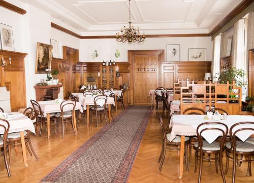 a dining room with tables and chairs and a chandelier at Hotel Hammer in Weiz