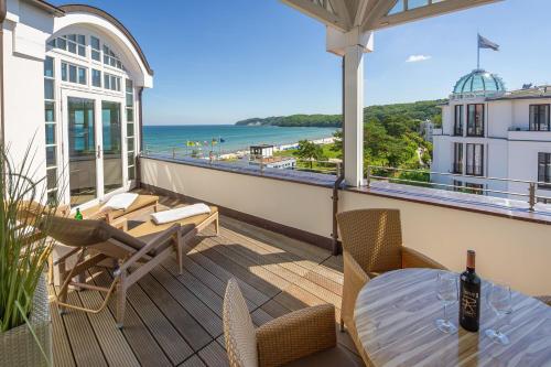 a balcony with a table and chairs and the ocean at Strandschloss Binz - Penthouse "Royal Beach" mit Sauna, Kamin, Terrasse, Meerblick in Binz
