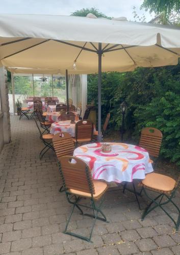 a group of tables and chairs under an umbrella at Hotel-Gasthof Lamm in Rot am See