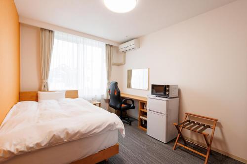 a hotel room with a bed and a desk at kkrshirahamamihamasou in Shirahama