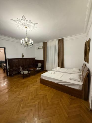 a bedroom with a bed and a chandelier at Kobuleti apartment in Kobuleti