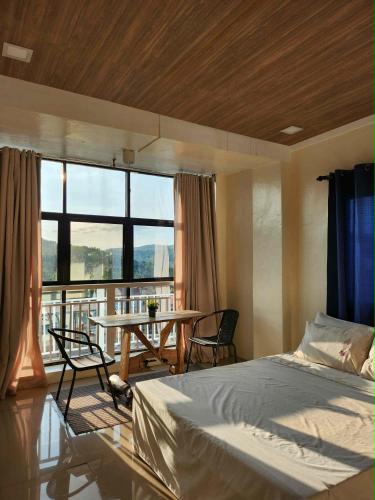 a bedroom with a bed and a table with chairs at R Hotel Centro and Restaurant in Marinduque