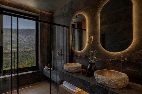 two sinks in a bathroom with two mirrors at Nekyra Villa in Zóla