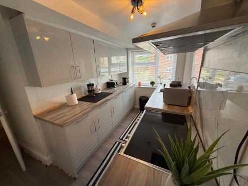 a kitchen with white cabinets and a large window at Grande Italia Rooms Comfort Italian Hospitality 4 in Ebley