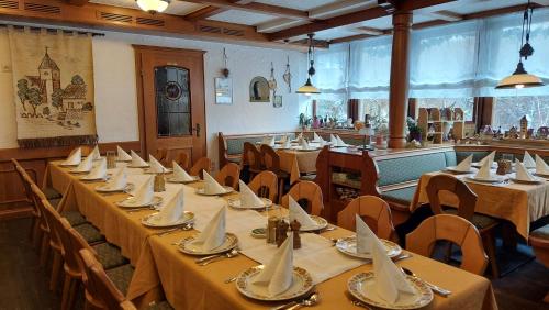 a row of tables with napkins on them in a restaurant at Hotel-Gasthof Lamm in Rot am See