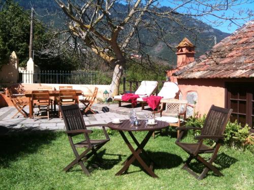 a patio with a table and chairs in the grass at Rural Las Llanadas in Los Realejos