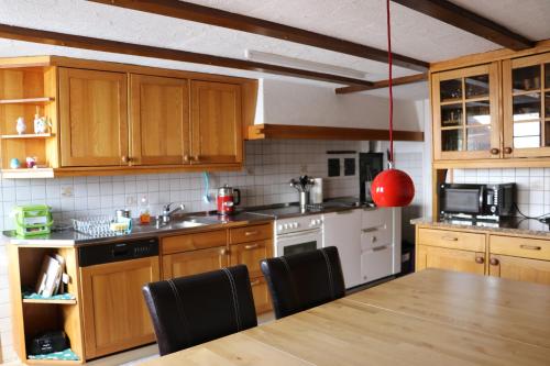 a kitchen with wooden cabinets and a table with chairs at Naturfreunde in Hergiswil