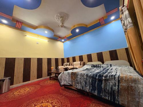 a bedroom with a bed and a blue ceiling at DANGWAL HoTEL in Srīnagar