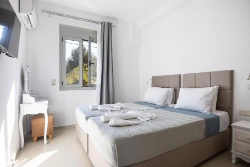 a bedroom with a bed with towels on it at A&E Cretan Oasis in Loutra