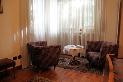 a living room with two chairs and a table at Villa Adele in Varese