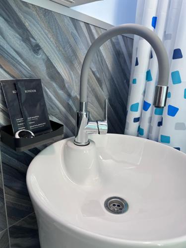 a bathroom sink with a book on top of it at Altura House in Almaty